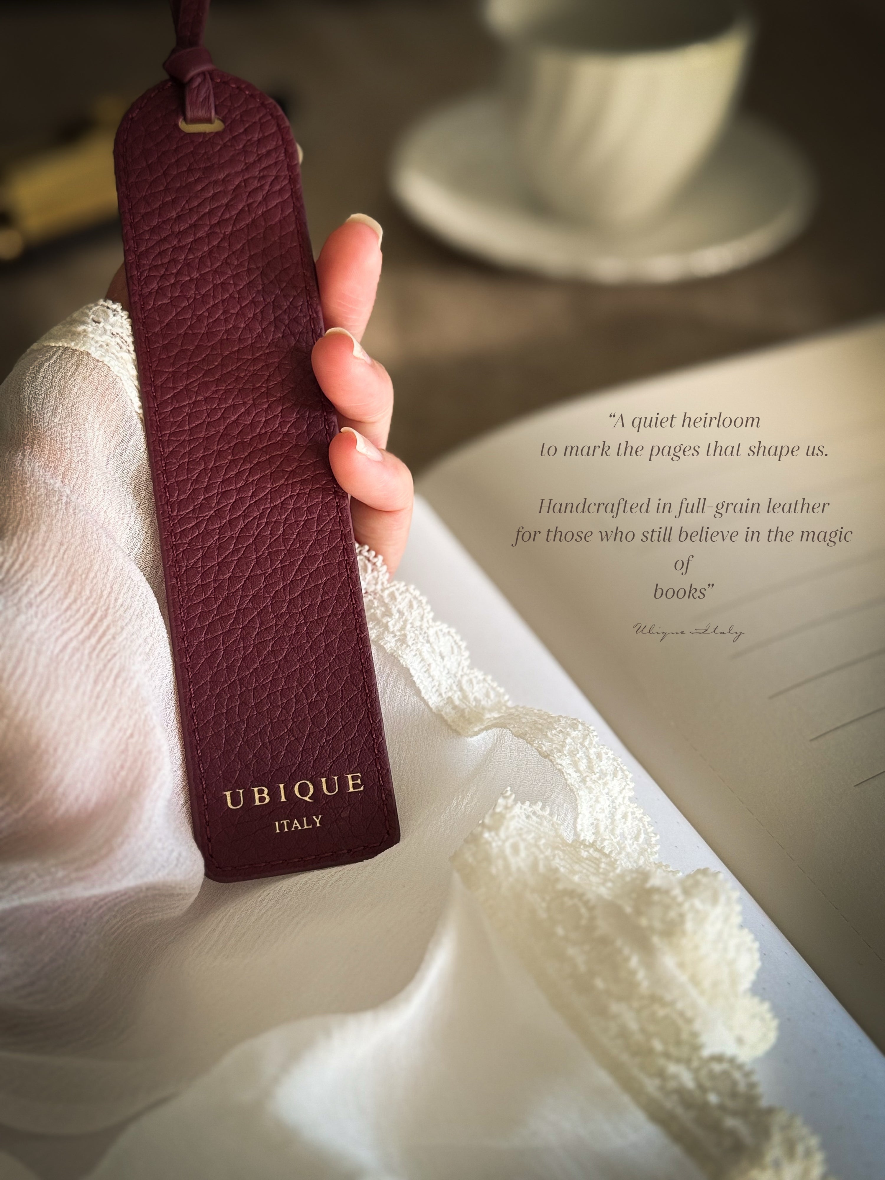 hand holding burgundy handcrafted leather bookmark tea cup journal lace cuff