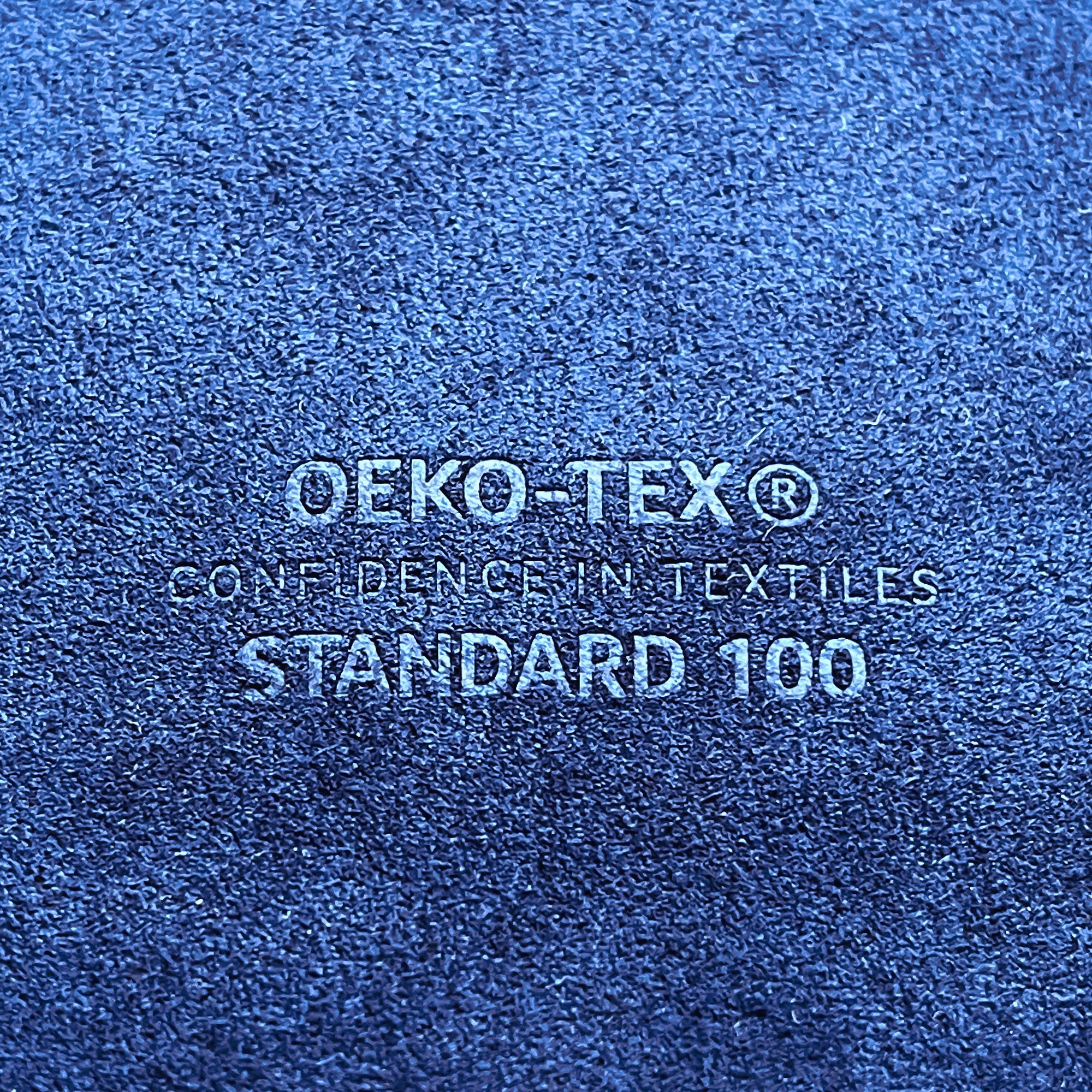 Blue fabric close up picture with OEKO-TEX STANDARD 100 embossed