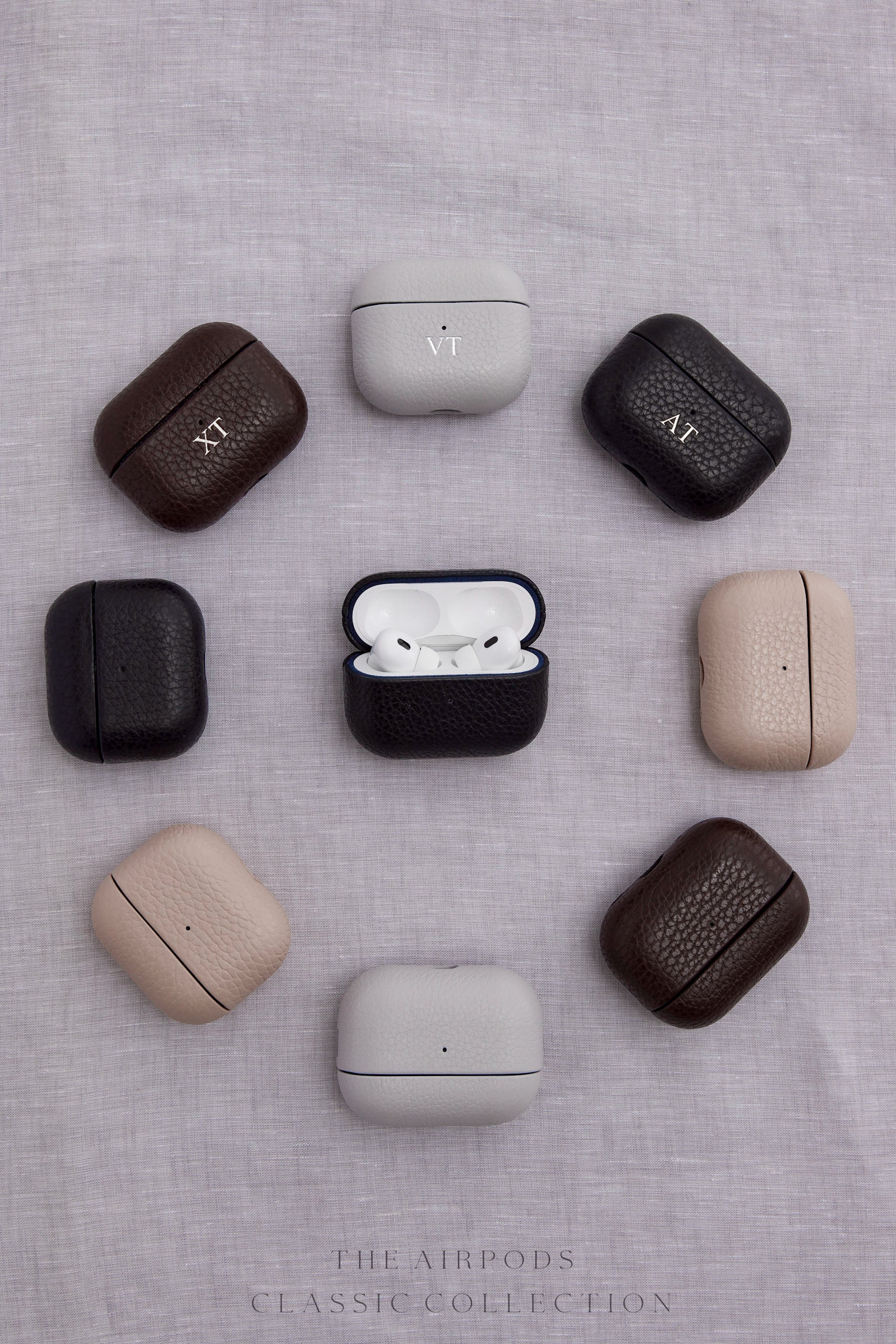 Ubique Italy Luxury Leather AirPods cases in black, brown, grey and nude on a linen background